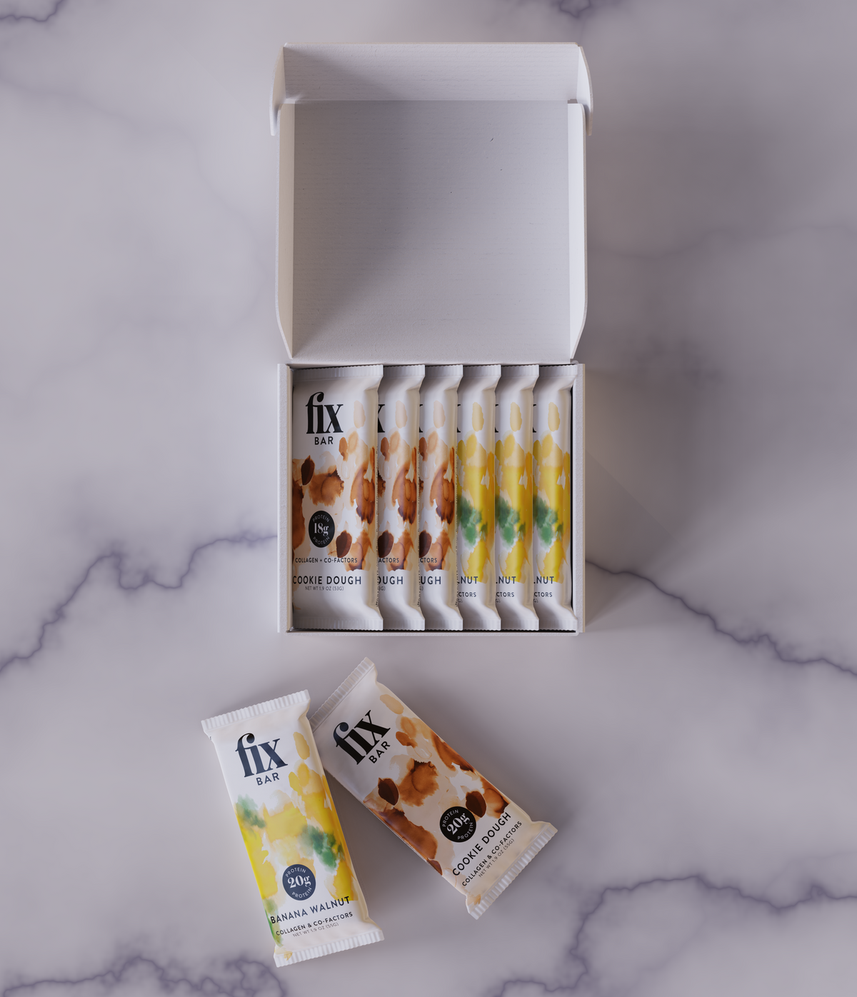 An open white box of FIX protein bars with several individual wrapped bars arranged beside it on a light gray marble surface.
